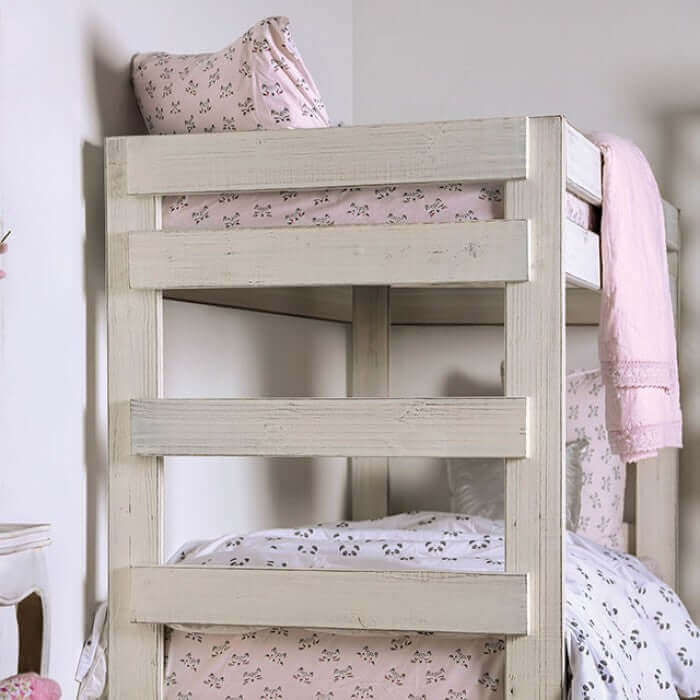 Rustic white pine wood bunk bed with pink bedding and decorative pillows in a cozy bedroom setting.