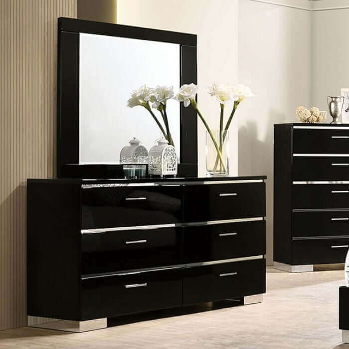 Erlach Gloss Black dresser with mirror and flowers, showcasing modern design and chrome accents in a stylish bedroom setting.
