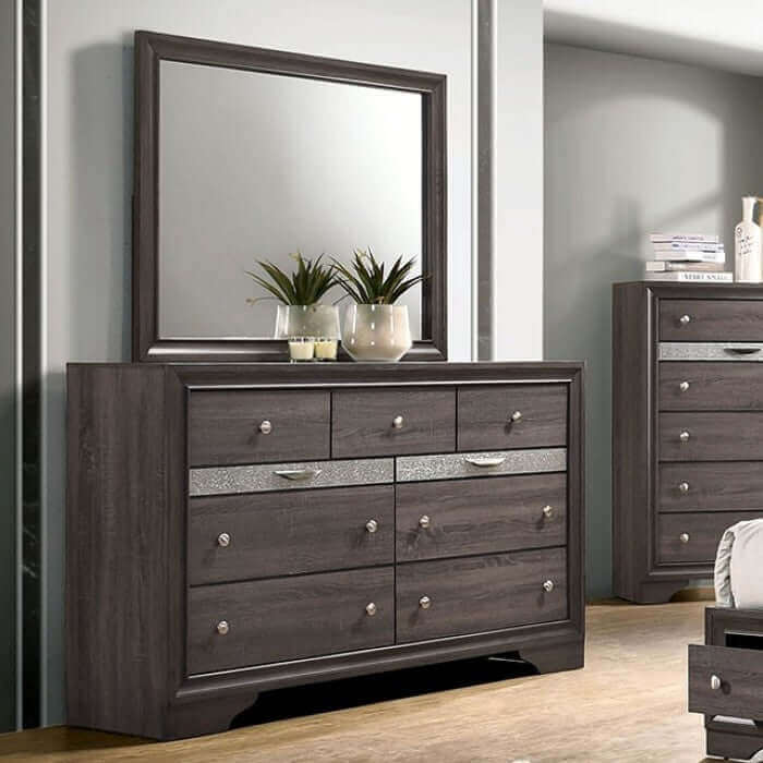 Modern gray dresser with mirror, featuring silver accents and jewelry drawer pulls, enhancing a chic bedroom aesthetic.