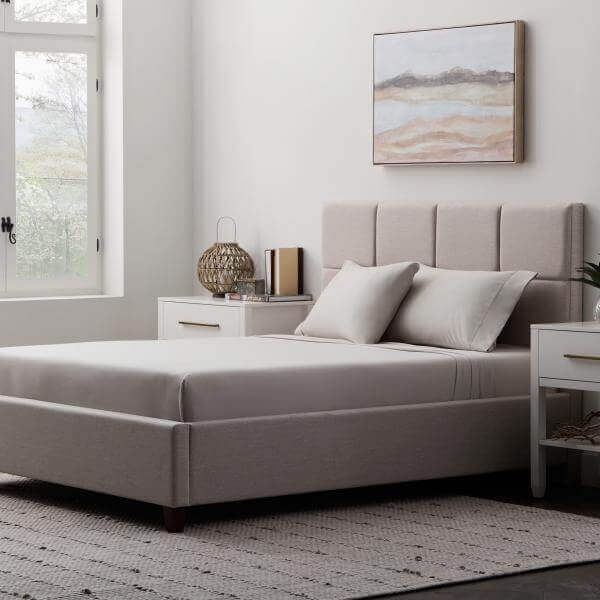 Cozy bedroom featuring Malouf Driftwood Soft Knit Microfiber Sheet Set on a stylish bed with neutral decor and natural light.