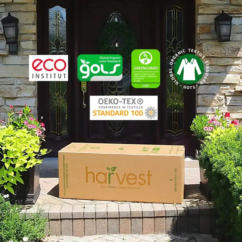 Harvest Green Essential mattress box with eco-certifications on porch surrounded by flowers, showcasing sustainable materials.