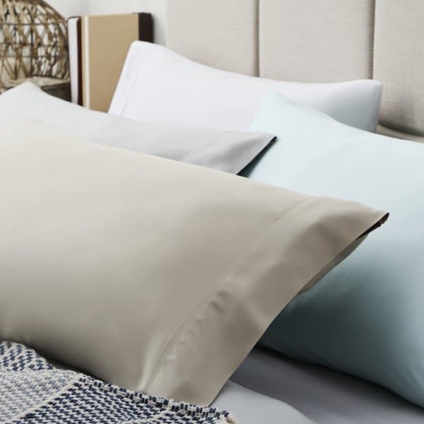 Malouf Smooth White Bamboo Rayon Pillowcase Set on a bed, showcasing silky, breathable fabrics in soft colors.