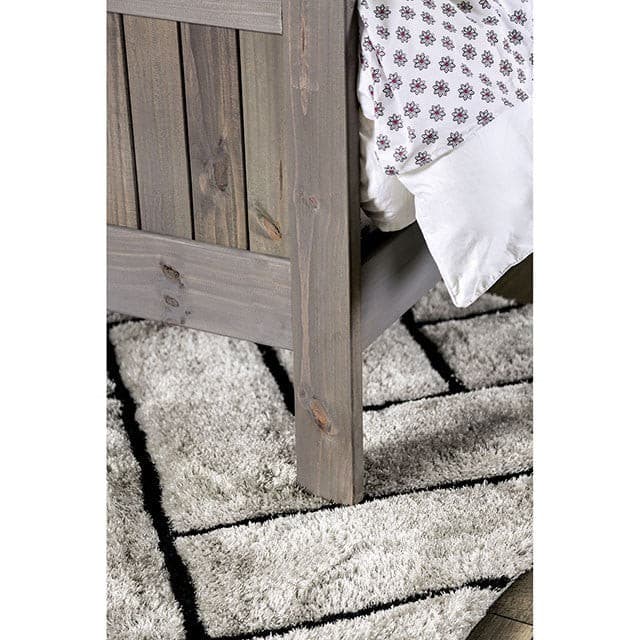 Rockwall Brushed Gray Panel Bed featuring a weathered finish and cozy bedding on a soft rug, enhancing bedroom comfort.