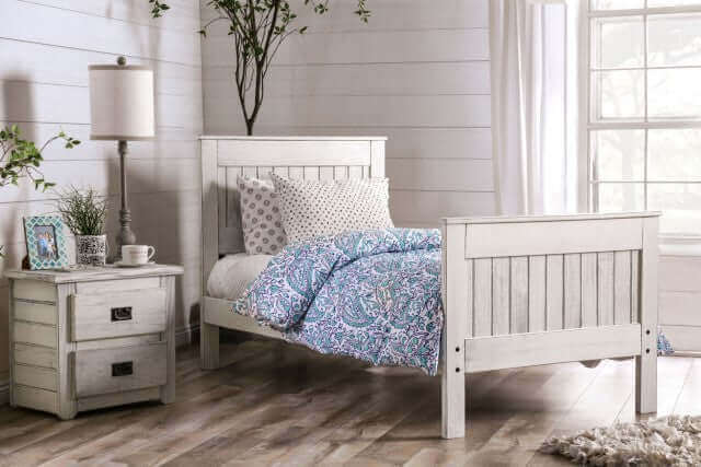 Rockwall brushed white panel bed in a cozy bedroom setting with a nightstand and decorative accessories.