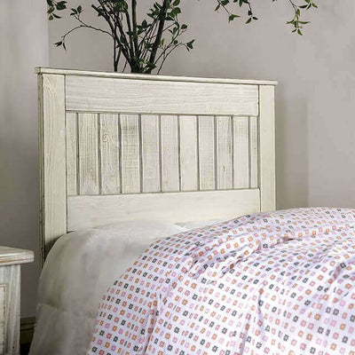 Distressed white wood headboard featuring rustic plank design, adding charm to a cozy bedroom setting.