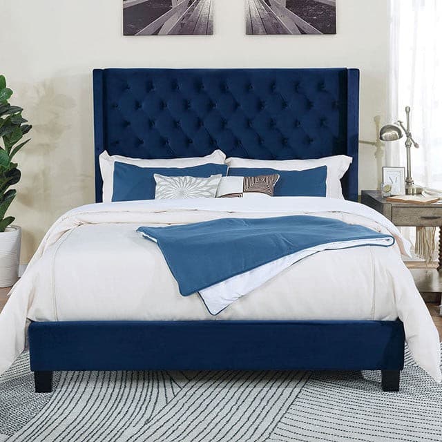 Elegant Ryleigh navy blue transitional bed with tufted headboard and soft bedding, enhancing modern bedroom decor.