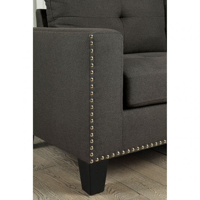 Close-up of Attwell Dark Gray Transitional Sofa with tufted seating and gold nailhead trim on the arm.