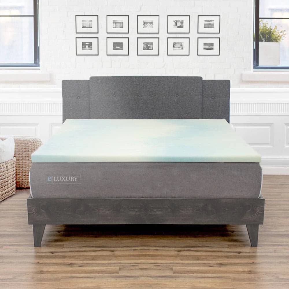 eLuxury 1.5" gel memory foam mattress topper displayed on a stylish bed in a modern room with framed pictures.