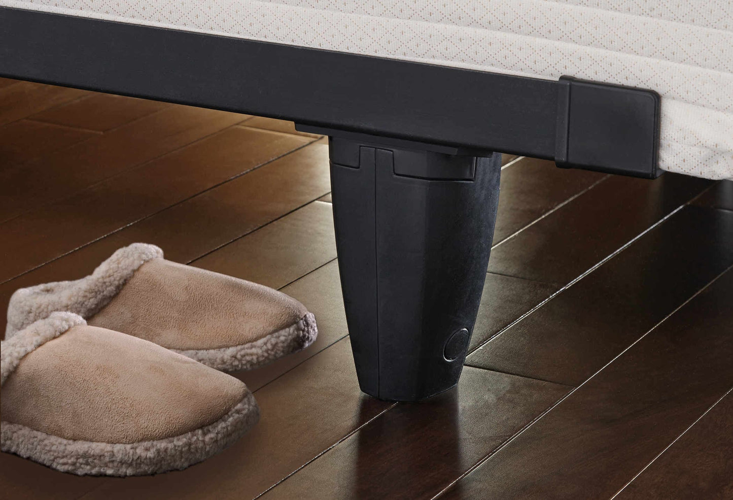 Knickerbocker enGauge™ bed frame leg on hardwood floor with cozy slippers nearby, showcasing sturdy design and style.