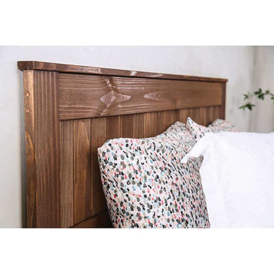 Close-up of Ila Wood Mahogany Headboard with rustic wooden design and patterned pillows in a cozy bedroom setting.