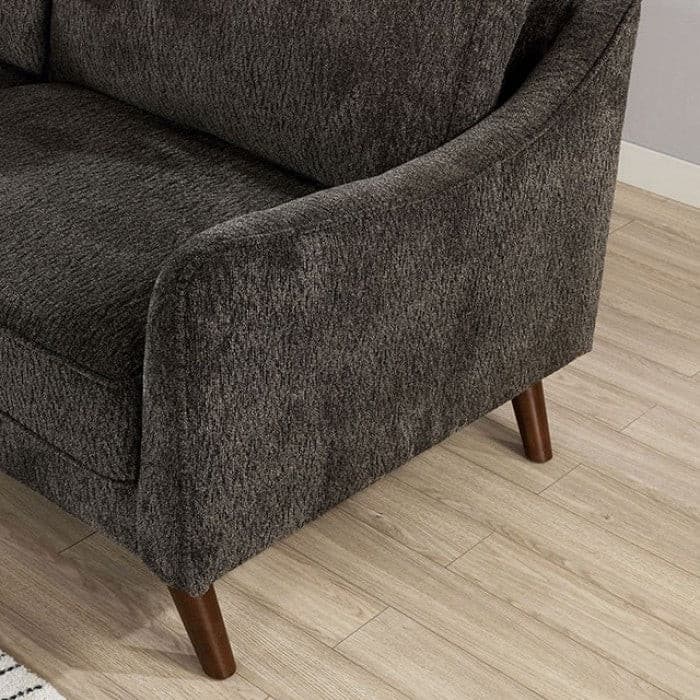 Close-up of Maxime Dark Gray Loveseat showing curved track arms and tapered wooden legs on a light wood floor.