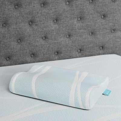 Tempur-Breeze° Neck + Advanced Cooling Pillow on a soft mattress, featuring a cool blue design and ergonomic shape for comfort.