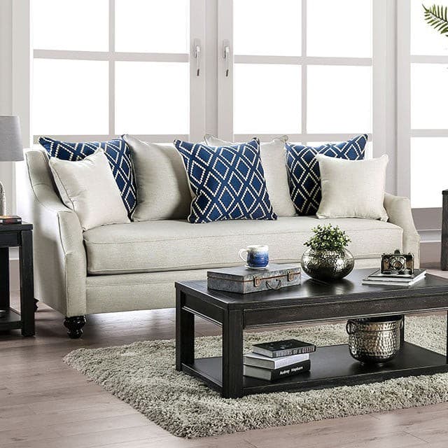 Nefyn Ivory Transitional Sofa with decorative blue throw pillows in a cozy lounge setting.