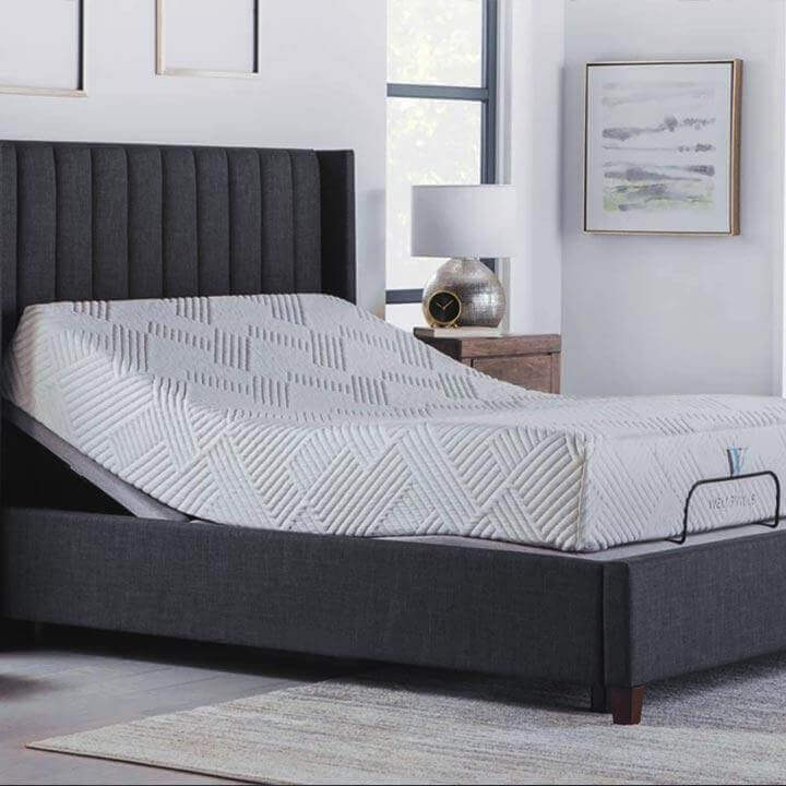 Ergo-Pedic Solutions III Massage Adjustable Base in a stylish bedroom setting with an elevated mattress.