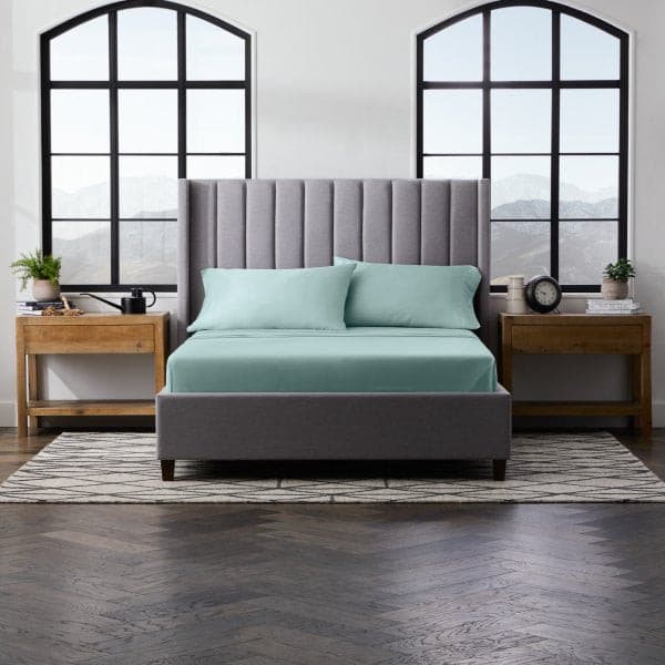 Modern bedroom featuring Malouf Smooth Rain Bamboo Rayon Pillowcase Set in turquoise on a stylish gray bed.