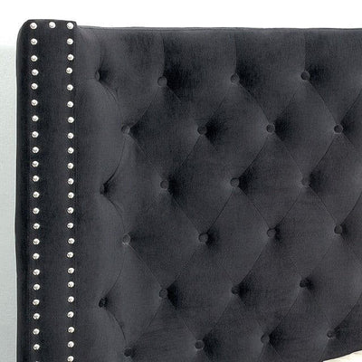 Black tufted wingback headboard with nailhead trim, adding elegance to any bedroom decor.