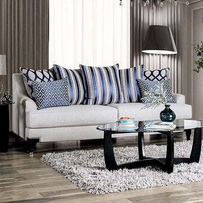 Light gray transitional sofa with patterned throw pillows, glass coffee table, and modern decor in a stylish living room setting.