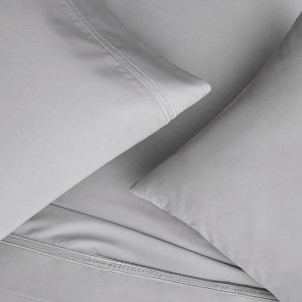 Light gray Supima® cotton pillowcase set on a bed, showcasing the luxurious sateen weave and extra-deep fit.
