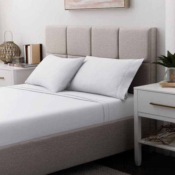 Cozy bedroom setup featuring Malouf white soft knit microfiber sheets on a neatly made bed with plush pillows and a stylish headboard.