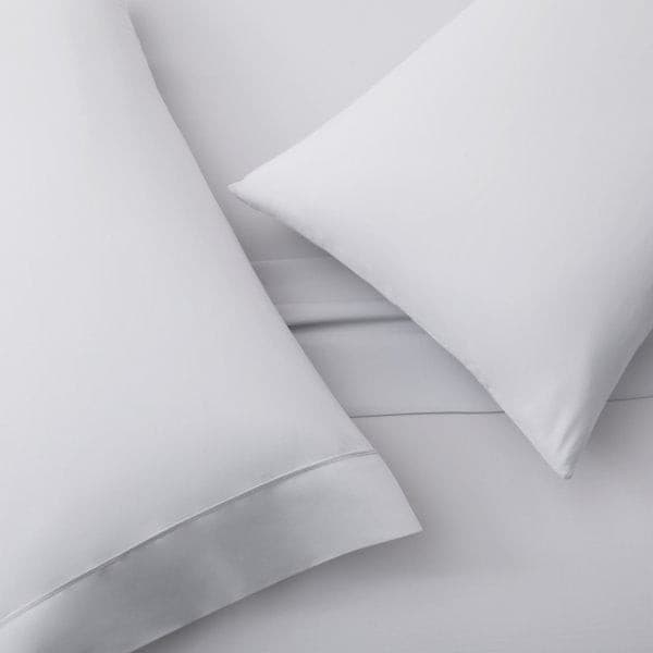 Soft white microfiber pillowcase set on a bed, showcasing cozy percale weave for a comfortable night's sleep.