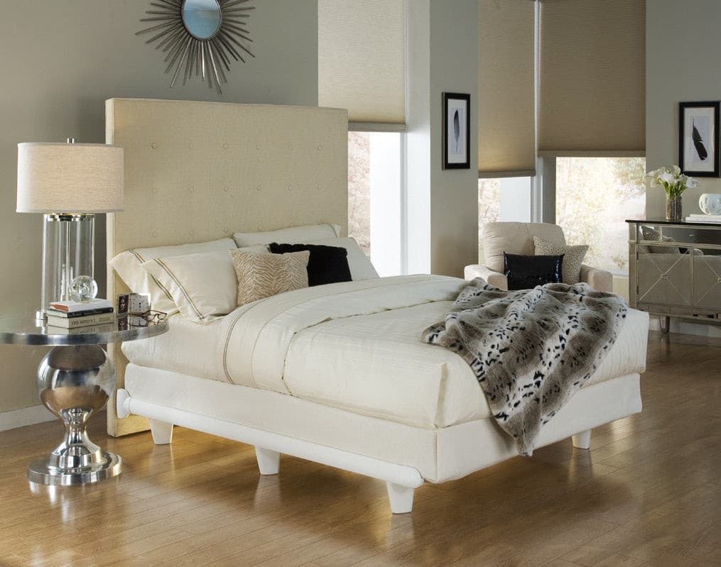 Stylish bedroom featuring a modern designer bed frame with a neutral color scheme and elegant decor elements.