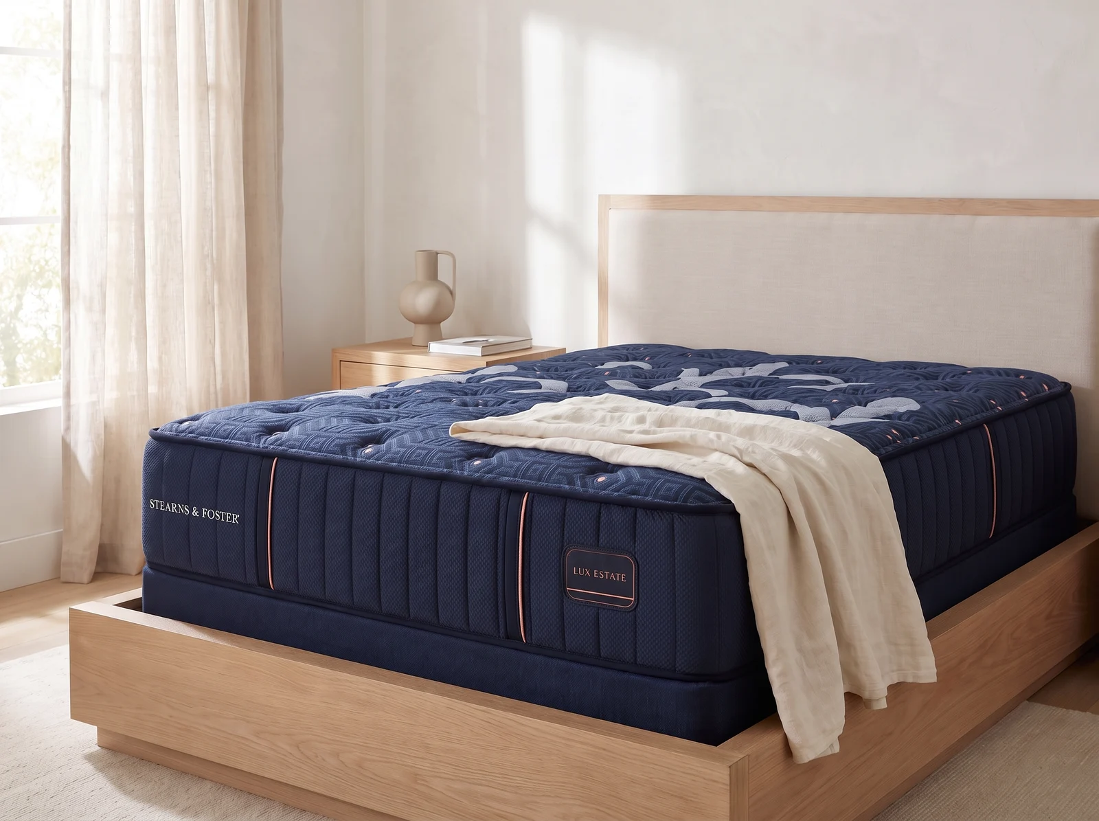 Deeply quilted navy Stearns & Foster Lux Estate mattress on a wood platform bed