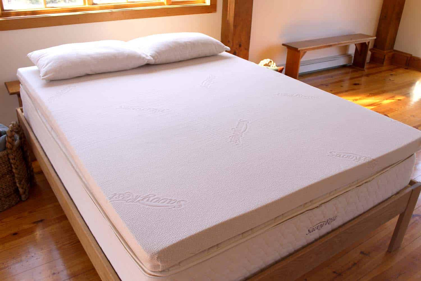 Queen Savvy Rest Vitality Organic Talalay latex mattress topper on a bed with two pillows, showcasing a soft and comfortable design.