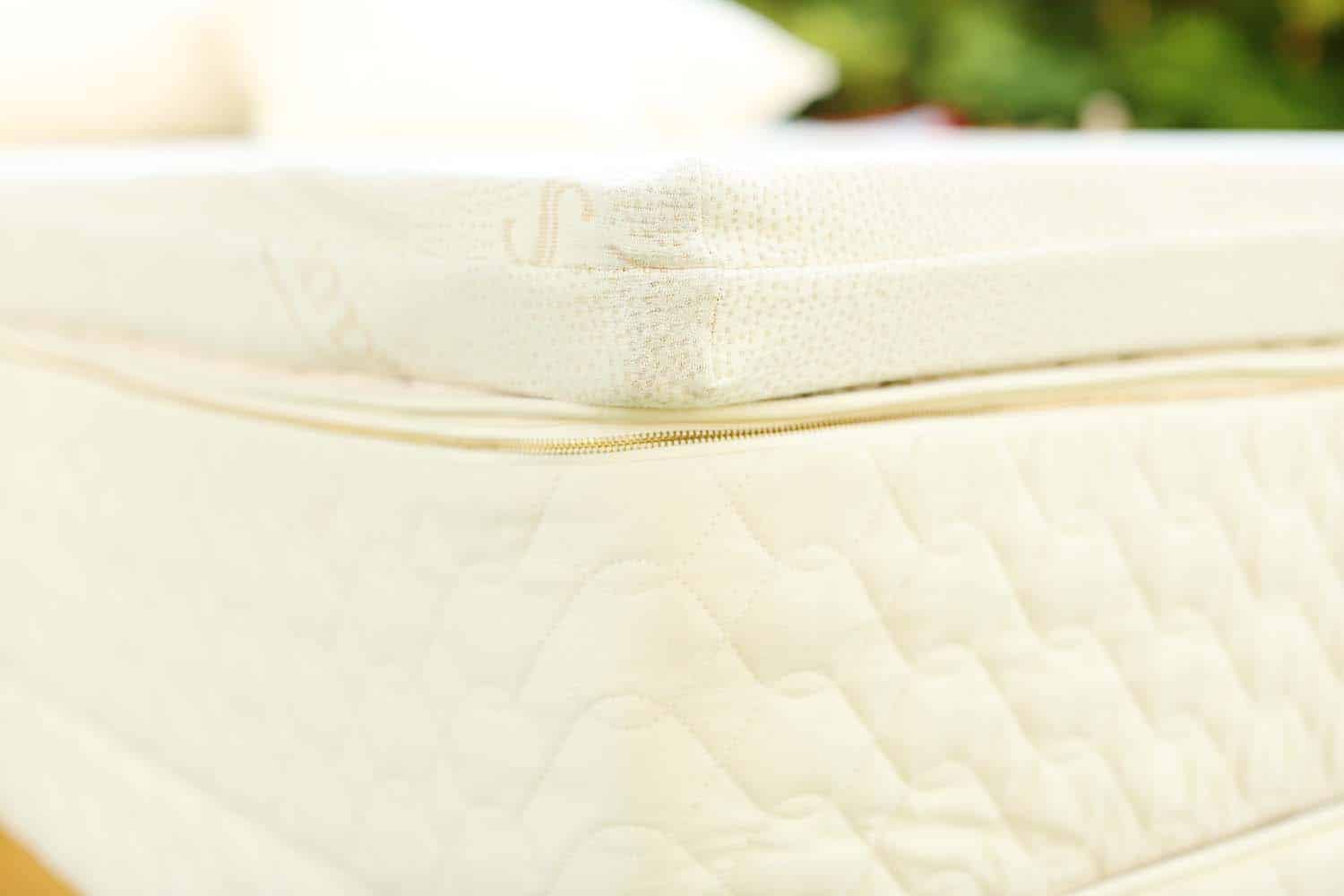 Close-up of the Queen Savvy Rest Vitality organic latex mattress topper in a natural cotton casing.