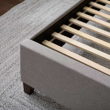 Malouf Eastman Charcoal Platform Bed Frame showcasing wood slats and soft fabric upholstery on a stylish rug.