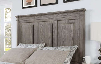 Durango Storage Bed headboard with intricate molding, stylish pillows, and framed artwork in a cozy bedroom setting.