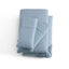 Malouf Pacific Soft Knit Microfiber Sheet Set in soft blue color, featuring pillowcases and fitted sheets with a smooth finish.