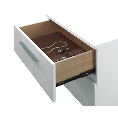 Open drawer of Carlie White Gloss Nightstand showcasing organized jewelry in a sleek design.