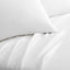 Close-up of Malouf white Tencel™ Lyocell pillowcase and sheets showcasing soft, smooth fabric texture.