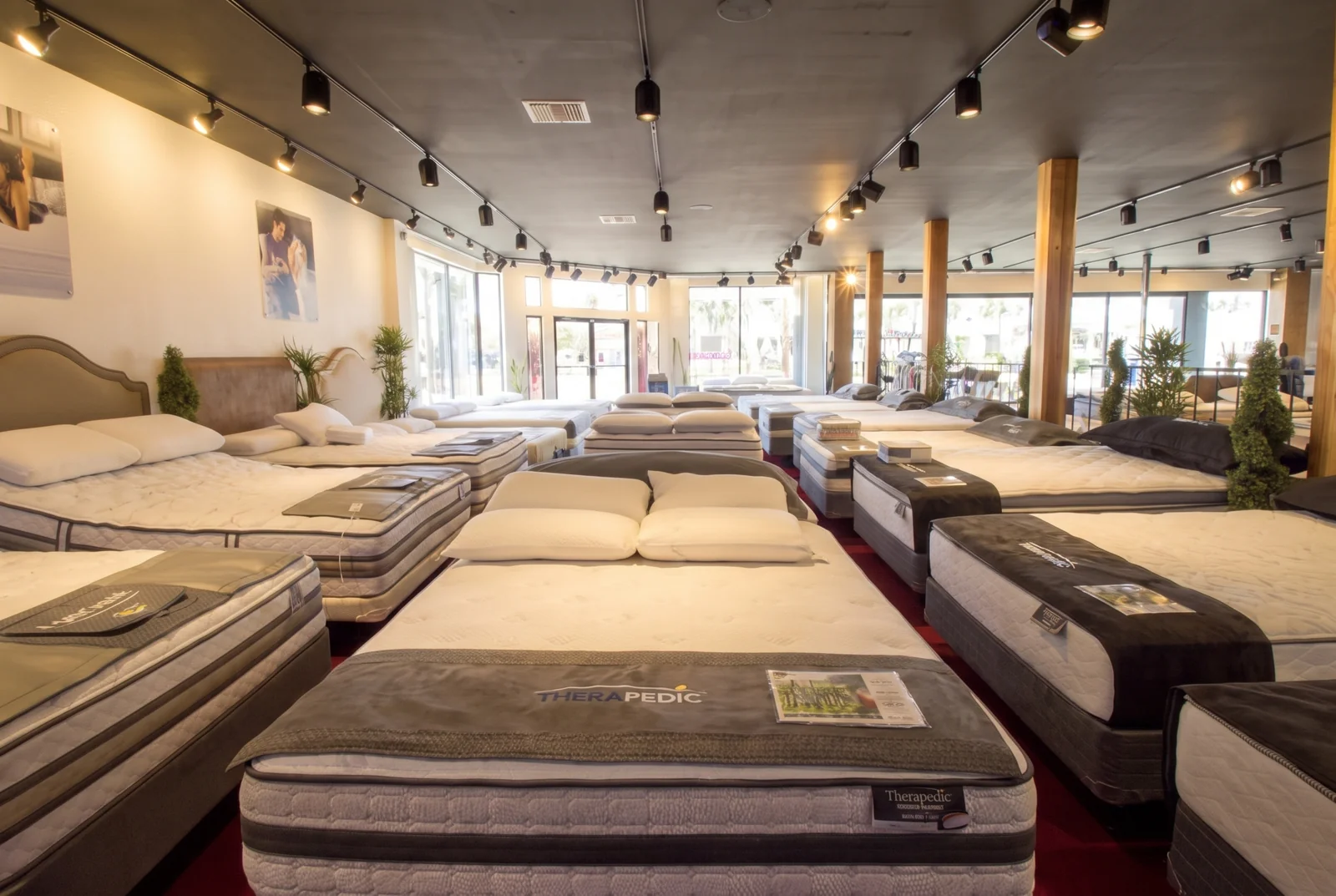 Recreated LA Mattress showroom with red carpet, timber columns and branded display beds