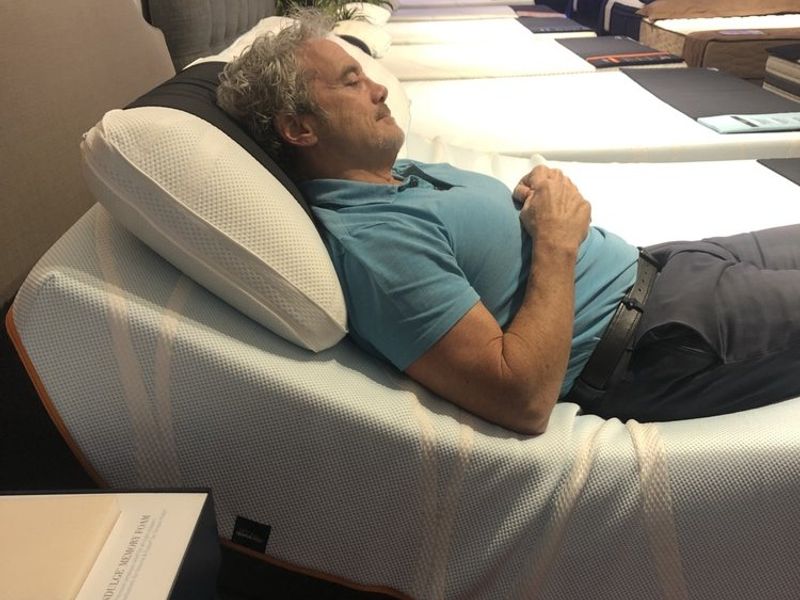 Customer testing an adjustable bed base at LA Mattress West LA showroom